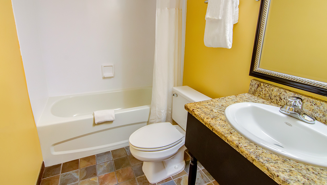 A bathroom with a bathtub, toilet, and sink